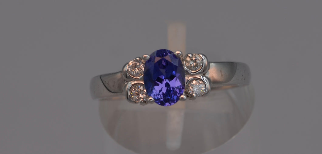 14K white gold ring with one center oval Tanzanite and four side diamonds