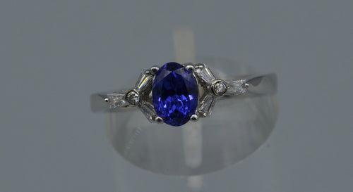 14K white gold ring with one center oval Tanzanite and six side Diamond baguettes